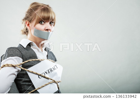 Businesswoman bound by contract with taped mouth. Businesswoman bound by contract with taped mouth. 136133942