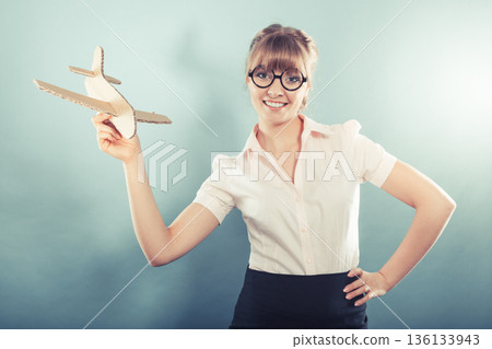 woman thinking about vacation holds airplane 136133943