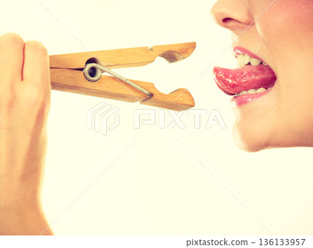 Blonde woman having tongue in clothespin Blonde woman having tongue in clothespin 136133957