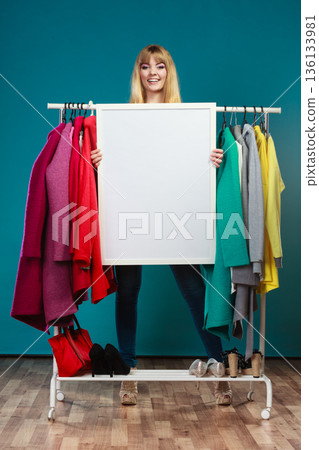 Woman in mall wardrobe with blank banner copyspace 136133981