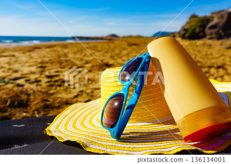 Sun protection gear on sand beach 136134001