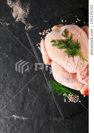 Whole frozen chicken with frost on black slate board garnished with dill and salt. Top view of raw poultry meat on dark stone background with copy space. High quality photo Whole frozen chicken with frost on black slate board garnished with dill and salt. Top view of raw poultry meat on dark stone background with copy space. High quality photo 136134101