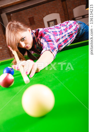 Young woman playing billiard. Young woman playing billiard. 136134215