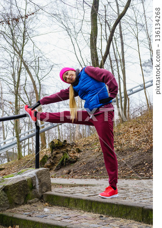 Sporty girl stretching outdoor in park. Sporty girl stretching outdoor in park. 136134268