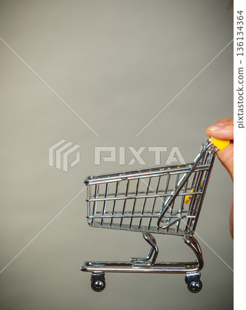 Woman hand holding small tiny shopping cart Woman hand holding small tiny shopping cart 136134364