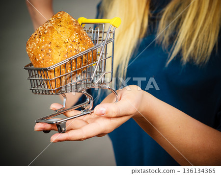 Woman hand holding shopping cart with bread 136134365