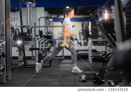 Fitness woman training leg muscles performing lunge exercise 136134520