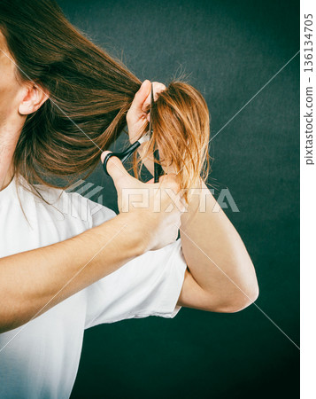 Male hands cutting long hair Male hands cutting long hair 136134705
