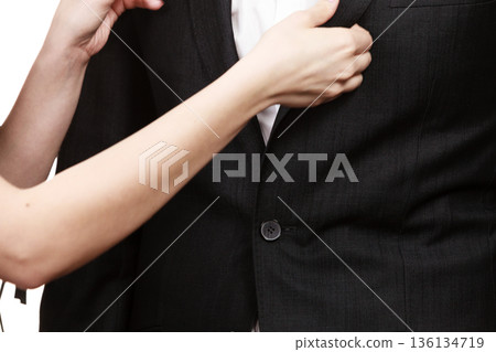 Woman helping man dress up elegant clothes. Woman helping man dress up elegant clothes. 136134719