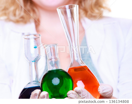Chemist woman holds test flask Chemist woman holds test flask 136134808