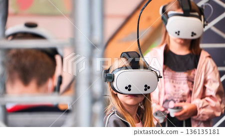 Children experiencing virtual reality with VR headsets for immersive education and gaming 136135181