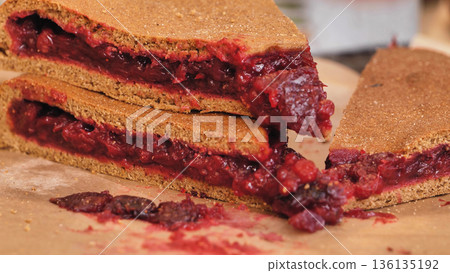 Berry pie slices showing fruit filling on parchment 136135192