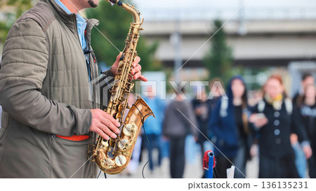 Street musician playing saxophone performing for crowd outdoors Street musician playing saxophone performing for crowd outdoors 136135231