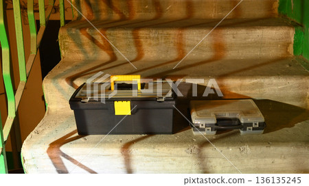 black toolbox and transparent case on the stairs 136135245