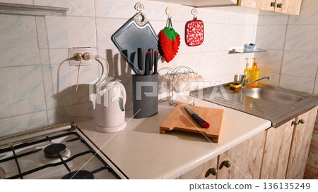 kitchen interior with kettle knives and a cutting board 136135249