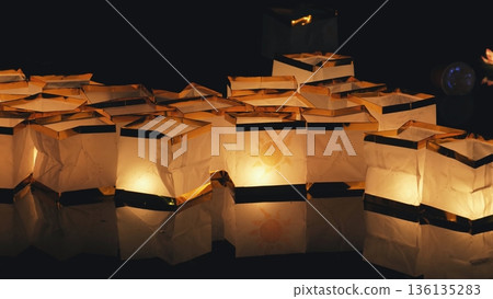 Floating paper lanterns illuminating river at night festival 136135283