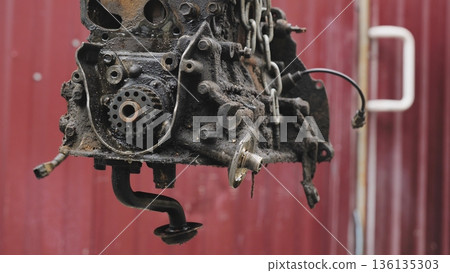 Car engine hanging in chain during repair process 136135303