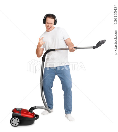 Cheerful man in headphones playing vacuum cleaner like a guitar. Funny guy cleaning house, dancing and singing isolated on white background Cheerful man in headphones playing vacuum cleaner like a guitar. Funny guy cleaning house, dancing and singing isolated on white background 136135424