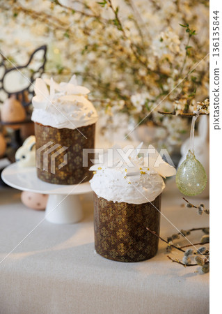 Easter cakes with icing and eggs on spring table, soft light Easter cakes with icing and eggs on spring table, soft light 136135844