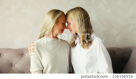 happy two women, mature mother and adult daughter together hugging at home 136136519
