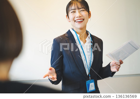 一位年輕的職業婦女在會議上做報告。 一位年輕的職業婦女在會議上做報告。 136136569