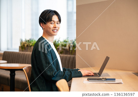 A young man working in a shared office 136136597
