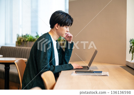 A young man working in a shared office 136136598