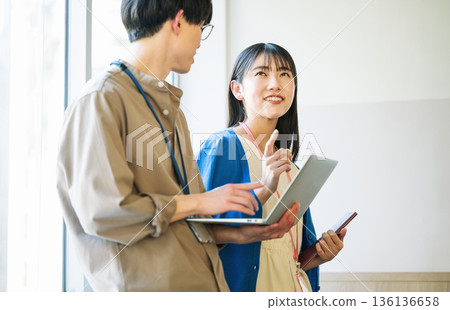 Young men and women chatting in the office 136136658