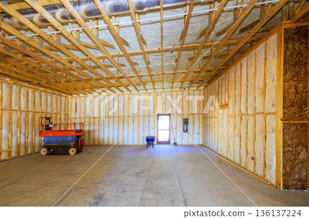 Large room under construction has insulation on walls, tools placed inside an entry door Large room under construction has insulation on walls, tools placed inside an entry door 136137224
