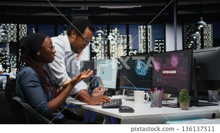 Team of programmers in office working together to block hacker intrusion. Teamworking IT company cybersecurity division colleagues coordinating incident response for scammer attacks 136137511