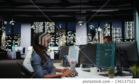 Female programmer using large language model application to get help with coding tasks. African american woman interacting with AI LLM chatbot PC GPT software on PC Female programmer using large language model application to get help with coding tasks. African american woman interacting with AI LLM chatbot PC GPT software on PC 136137521