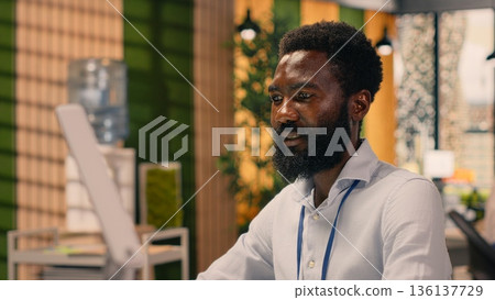 Black businessman, analytics on laptop, performance metrics, modern office. Visual data, graphs and KPI reports, strategic decision making, multinational company, global business. Black businessman, analytics on laptop, performance metrics, modern office. Visual data, graphs and KPI reports, strategic decision making, multinational company, global business. 136137729