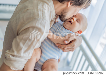 Father gently placing his baby into a crib at home, creating a calm and safe bedtime moment. Caring fatherhood scene filled with trust and warmth. Parenting, infant sleep and family bonding concept 136138207