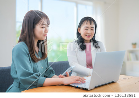 Two women using a PC 136138681