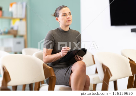 female student with a tablet in her hands listens to a lecture female student with a tablet in her hands listens to a lecture 136139650
