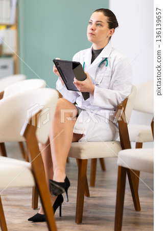 During lecture, young woman medical listener makes notes on tablet During lecture, young woman medical listener makes notes on tablet 136139657