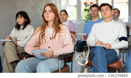 Young female student listening to lecture with focus 136139883