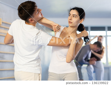 Self defense lesson - woman learns to fight back an attacking man 136139922