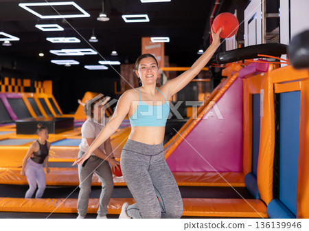 Young woman playing ball in trampoline center Young woman playing ball in trampoline center 136139946