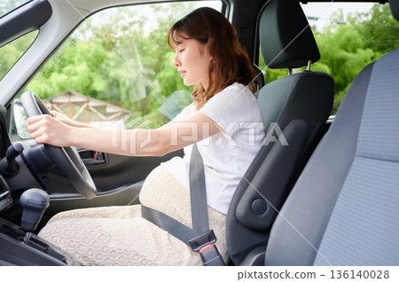 Driving woman, pregnant woman, child 136140028