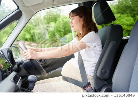 Driving woman, pregnant woman, child Driving woman, pregnant woman, child 136140049