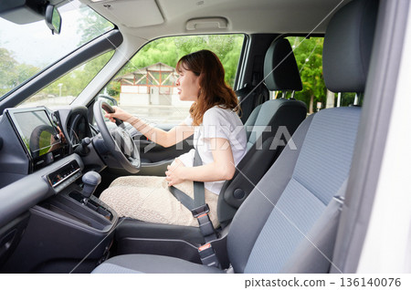 Driving woman, pregnant woman, child 136140076