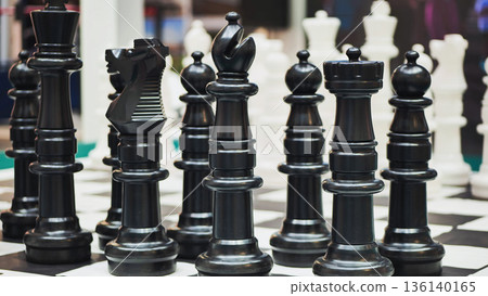 Black chess pieces standing on a chessboard are ready for a new game 136140165