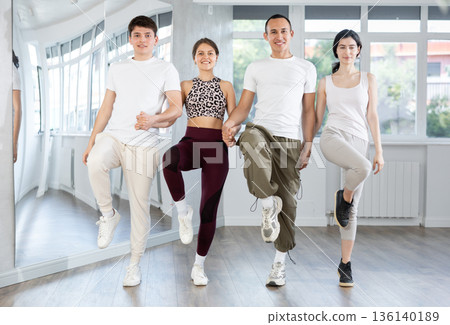 Smiling young multinational men and women dancing catalan typical Sardanas in dance salon Smiling young multinational men and women dancing catalan typical Sardanas in dance salon 136140189