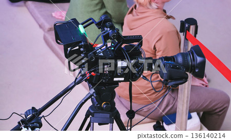 Professional video camera on tripod filming event, covering live broadcast media production Professional video camera on tripod filming event, covering live broadcast media production 136140214
