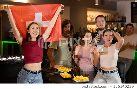 Group of fans in bar with Swiss flag Group of fans in bar with Swiss flag 136140239
