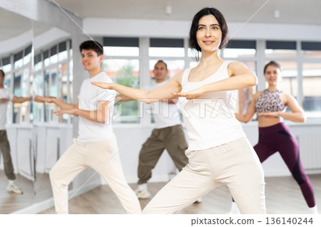 Cheerful brunette practicing energetic dance in choreography class Cheerful brunette practicing energetic dance in choreography class 136140244