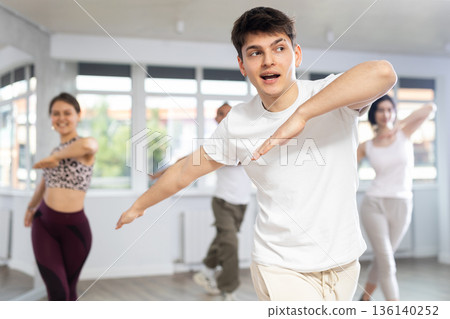 Guy enjoys active dancing, learns new movements, moves synchronously with participants of lesson Guy enjoys active dancing, learns new movements, moves synchronously with participants of lesson 136140252