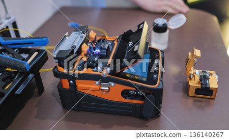 Fiber optic fusion splicer working at telecommunications technology exhibition 136140267