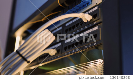 Ethernet cables connecting to a network switch in a data center rack 136140268